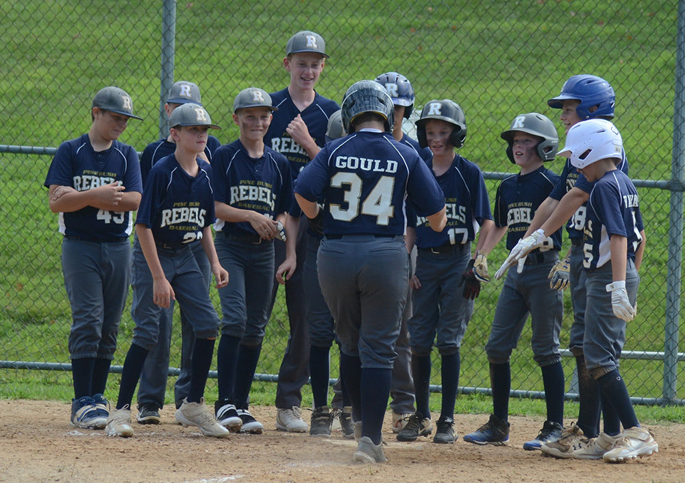 The Pine Bush Rebels greet Ben Gould at the plate after hitting a grand slam during Saturday’s New York Elite Baseball Around the Horn 12U tournament game at the Town of Newburgh Little League complex.